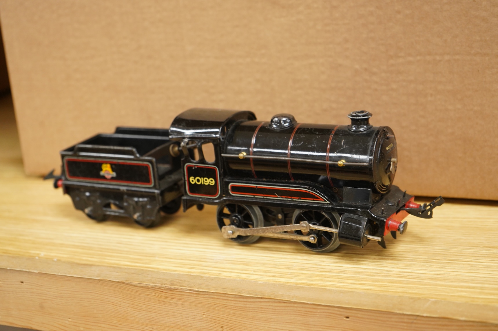 A collection of 0 gauge Hornby tinplate clockwork railway, including four BR locomotives, 17 freight wagons and four wheel coaches, together with a station building, signal cabin, and Goods depot (missing base), plus a f